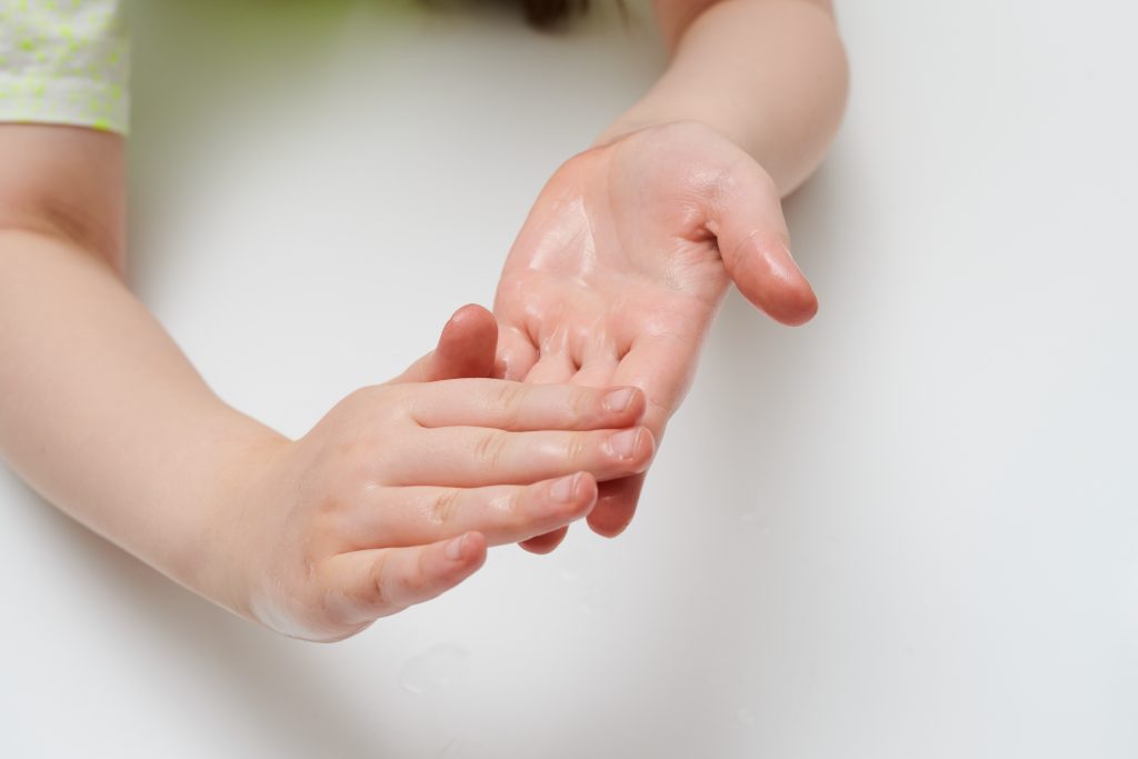 Child Rubbing Antibacterial Gel On Hands Isolated White